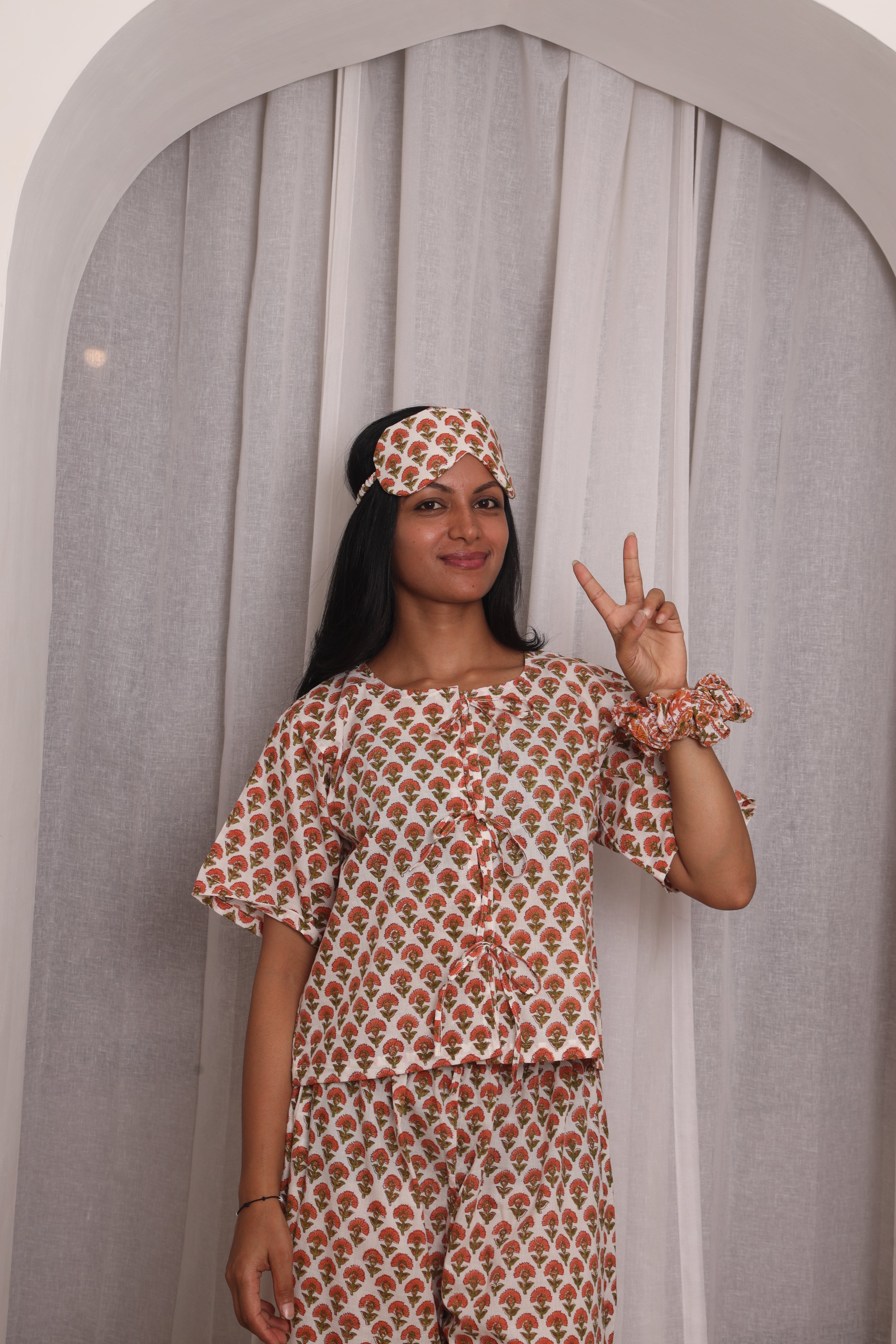 Woman wearing breathable cotton sleepwear in a relaxed bedroom setting for comfortable sleep in warm weather